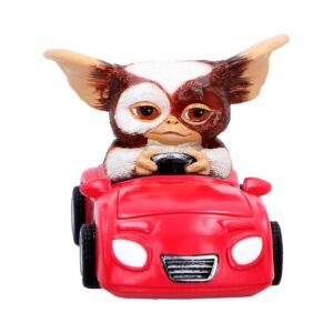 Toy Gizmo driving a small red car, facing forward with a determined expression.