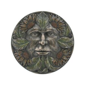 Round metal medallion with a carved human face framed by a wreath of leaves and sunflower blossoms in relief