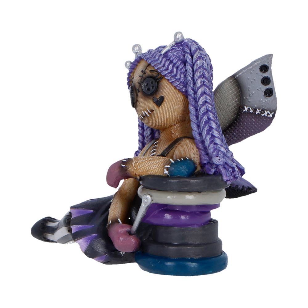 Handmade stitched doll with purple braided hair and a button eye, sitting on a stack of colored rings with wing-like back accessory.