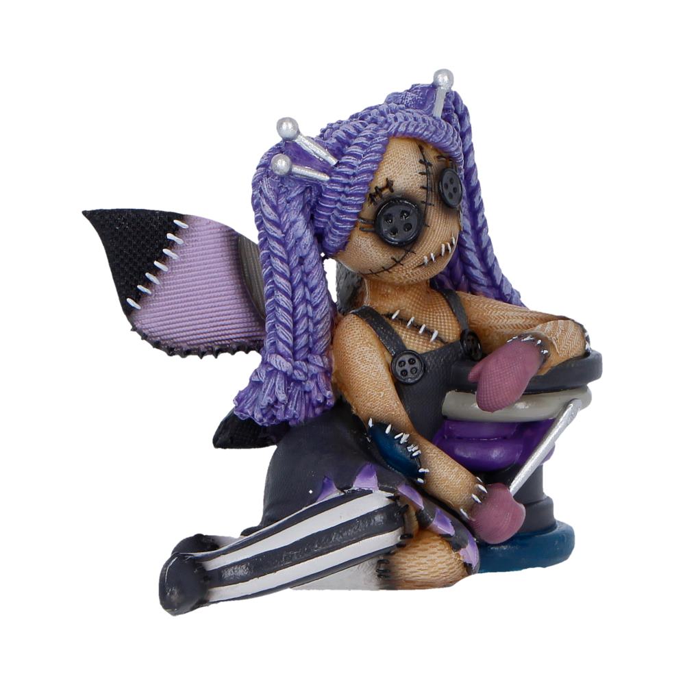Handmade plush monster with purple braided hair, button eyes, and stitches, sitting on a mini skateboard.