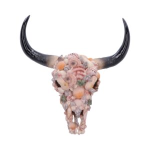 Decorative bull skull covered in seashells and adorned horns against a white background