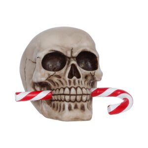 Decorative skull biting a red-and-white candy cane, a Halloween prop.