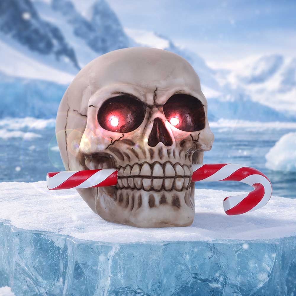 Skull with glowing red eyes biting a red-and-white candy cane on an icy surface.