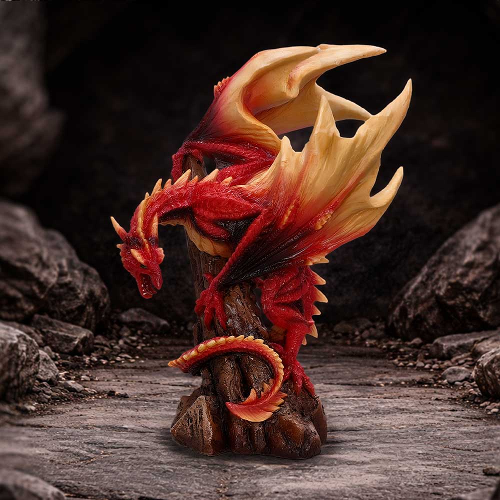 Red and cream dragon statue perched on a rocky pedestal against a dark background.