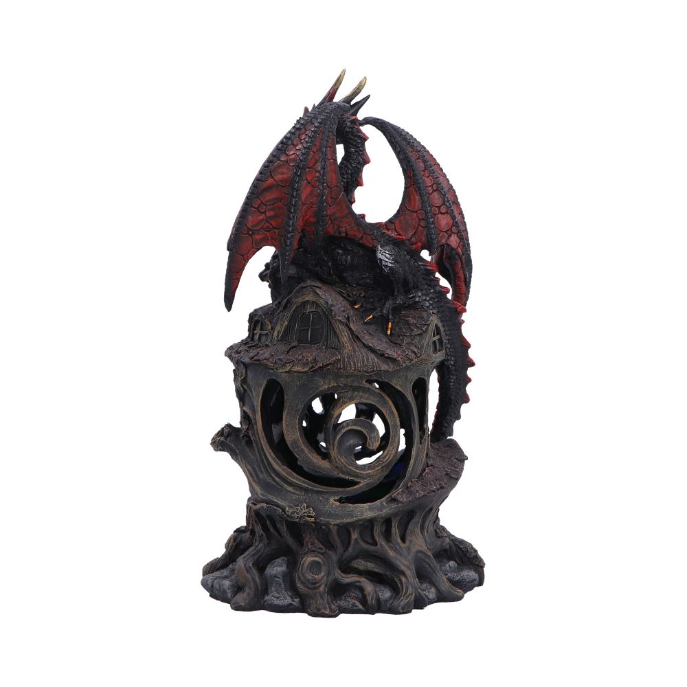 Red and black dragon statue perched on a dark, spiraling carved pedestal with a hollow circular opening below
