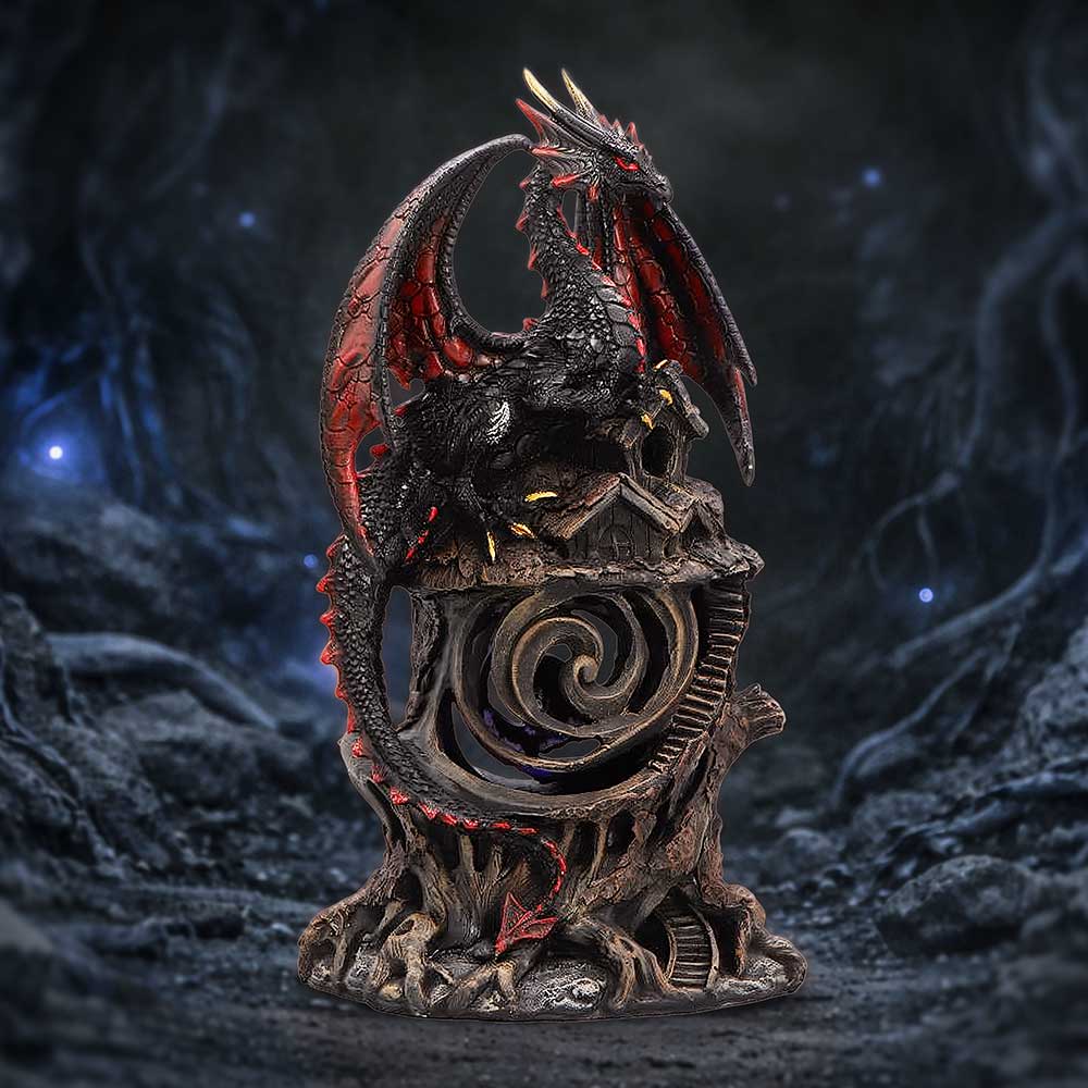 Detailed dragon statue: black and red dragon perched on a carved pedestal with a spiraling central design in a dark, cavernous setting.