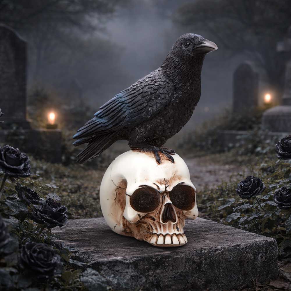 Raven perched on a cracked skull atop a tomb in a foggy graveyard at dusk.